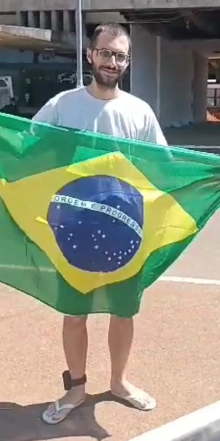 João Giffoni com a bandeira e a tornozeleira eletrônica, em Brasília. Acervo pessoal de João Giffoni